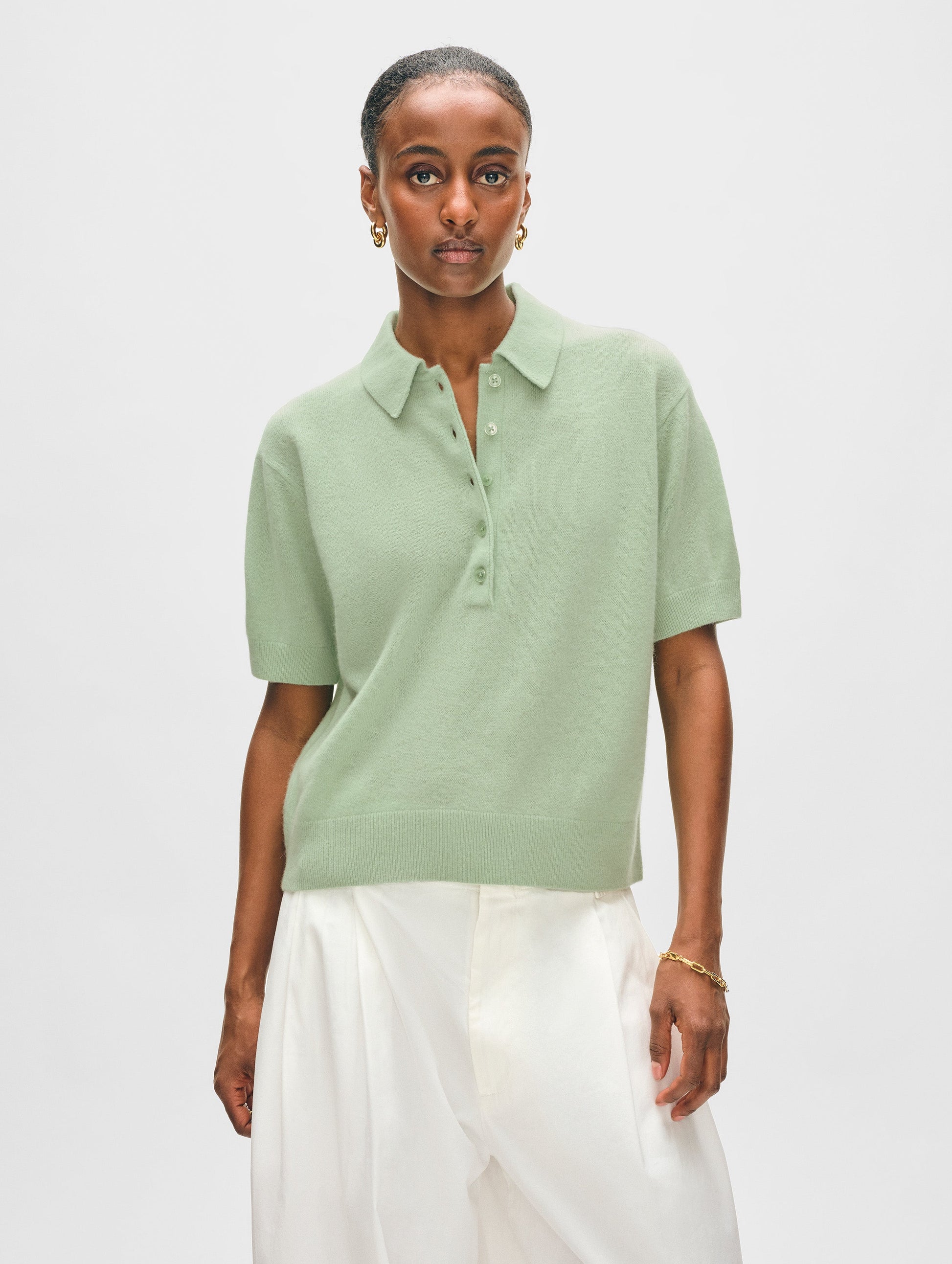 Model wearing sage green cashmere button polo.