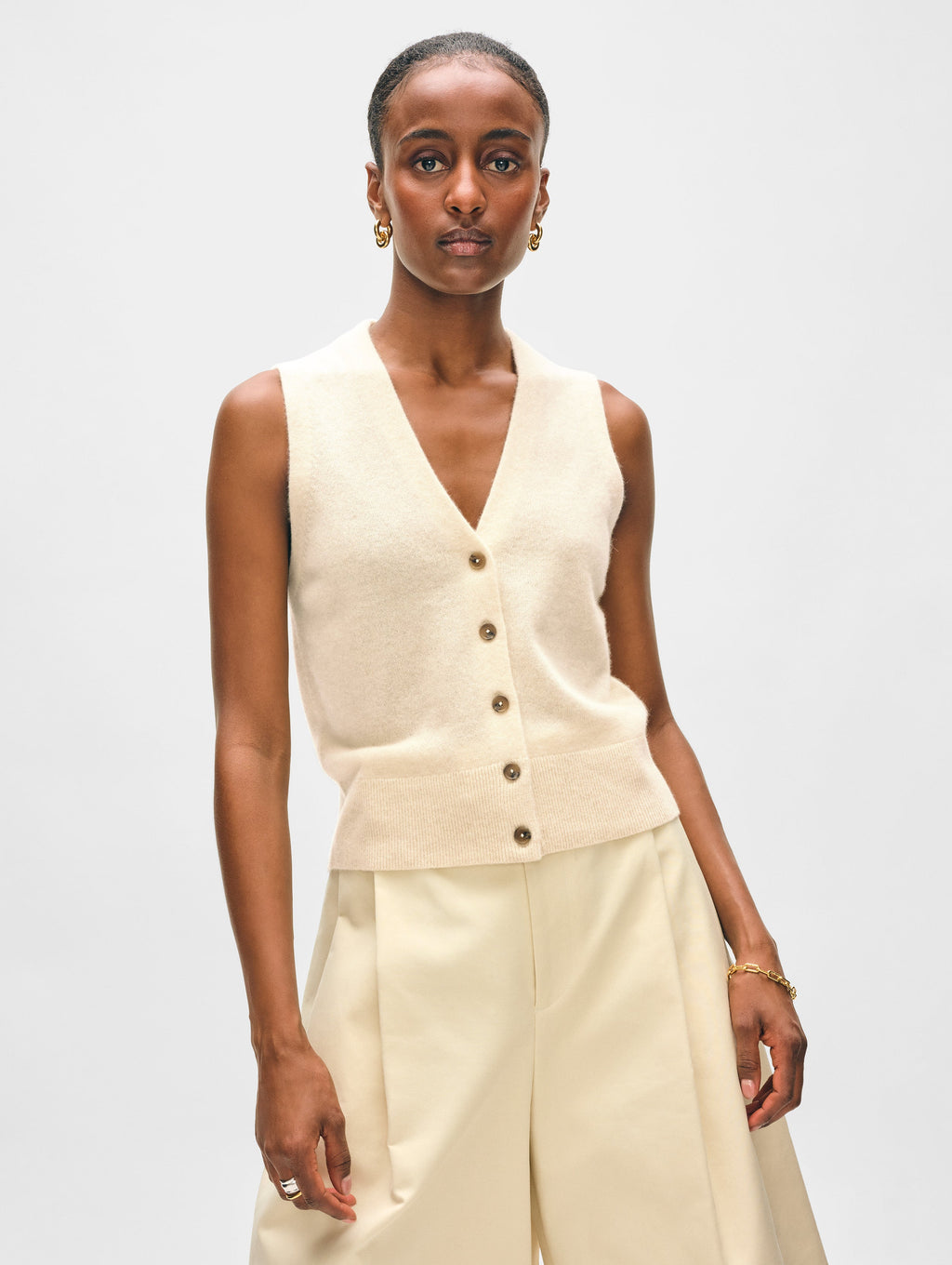 Model wearing cream button up vest.