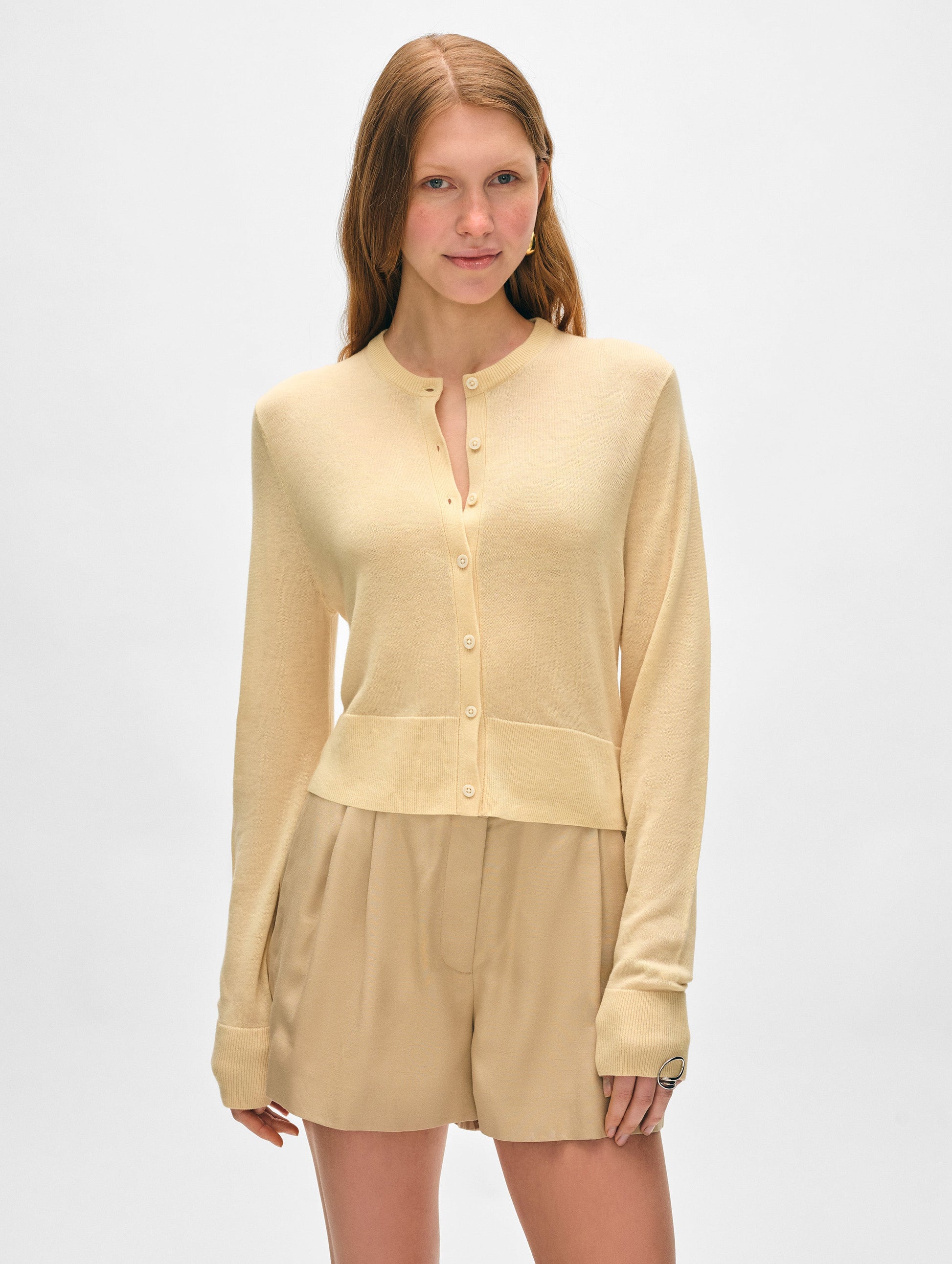 Model wearing butter yellow superfine cashmere button cardigan.